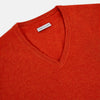 View 2 of product The Turnbull & Asser Red Orange Cashmere V-neck Jumper features long sleeves, ribbed cuffs and hem, displayed on a plain white background—a stylish knitwear essential for any wardrobe.