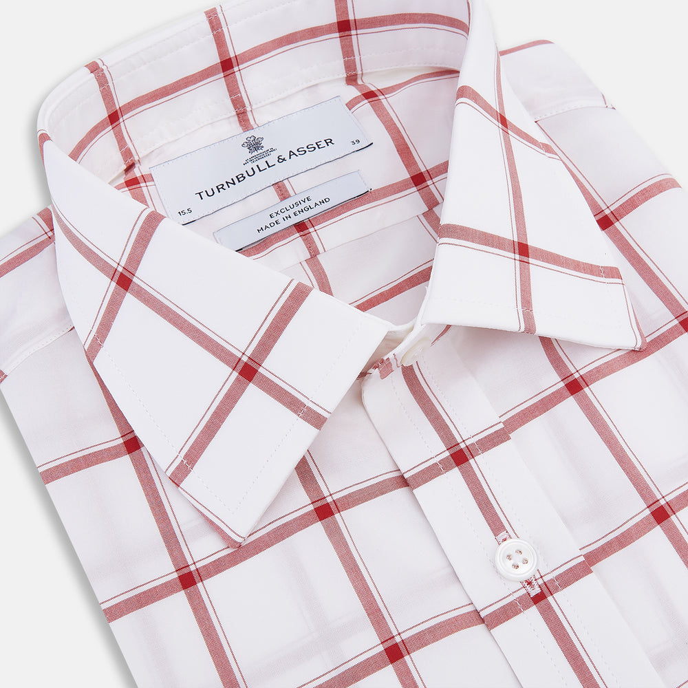 The Turnbull & Asser Dark Red Grid Check Mayfair Shirt is a long-sleeve white shirt made from Italian cotton, featuring a bold dark red grid pattern, button-down front, and classic collar, shown laid flat on a white background.