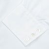 View 6 of product A neatly folded Turnbull & Asser Two-Fold 200 White Cotton Shirt with a Regent collar and 3-button cuffs, crafted from breathable fabric, is displayed on a light grey background with the label visible inside the collar.