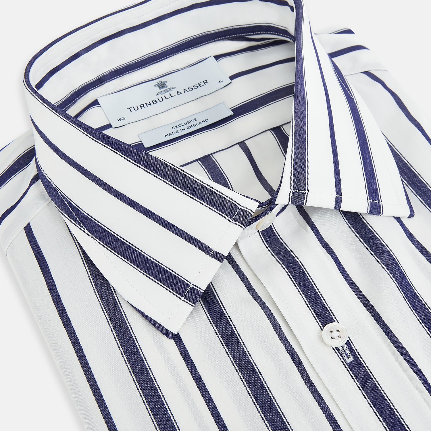 View 2 of product The Navy Double Stripe Mayfair Shirt by Turnbull & Asser features classic long sleeves, buttoned cuffs, a collar, and a slightly curved hem with timeless vertical navy and white stripes.