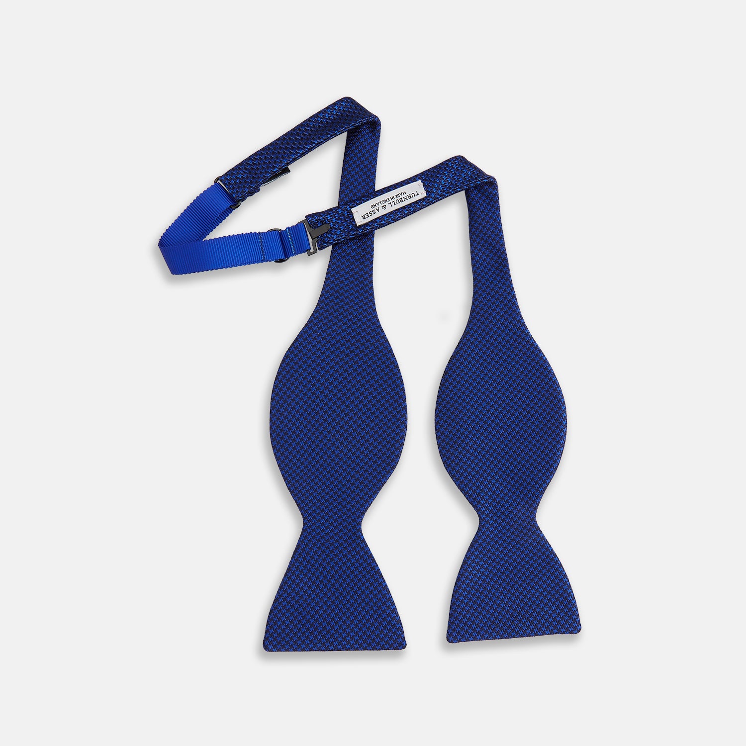 View 2 of product The HOUNDSTOOTH NAVY CRUISE BOW TIE by Turnbull & Asser features a refined textured pattern in blue, neatly tied and set against a white background—a stylish, versatile accessory for the modern gentleman.