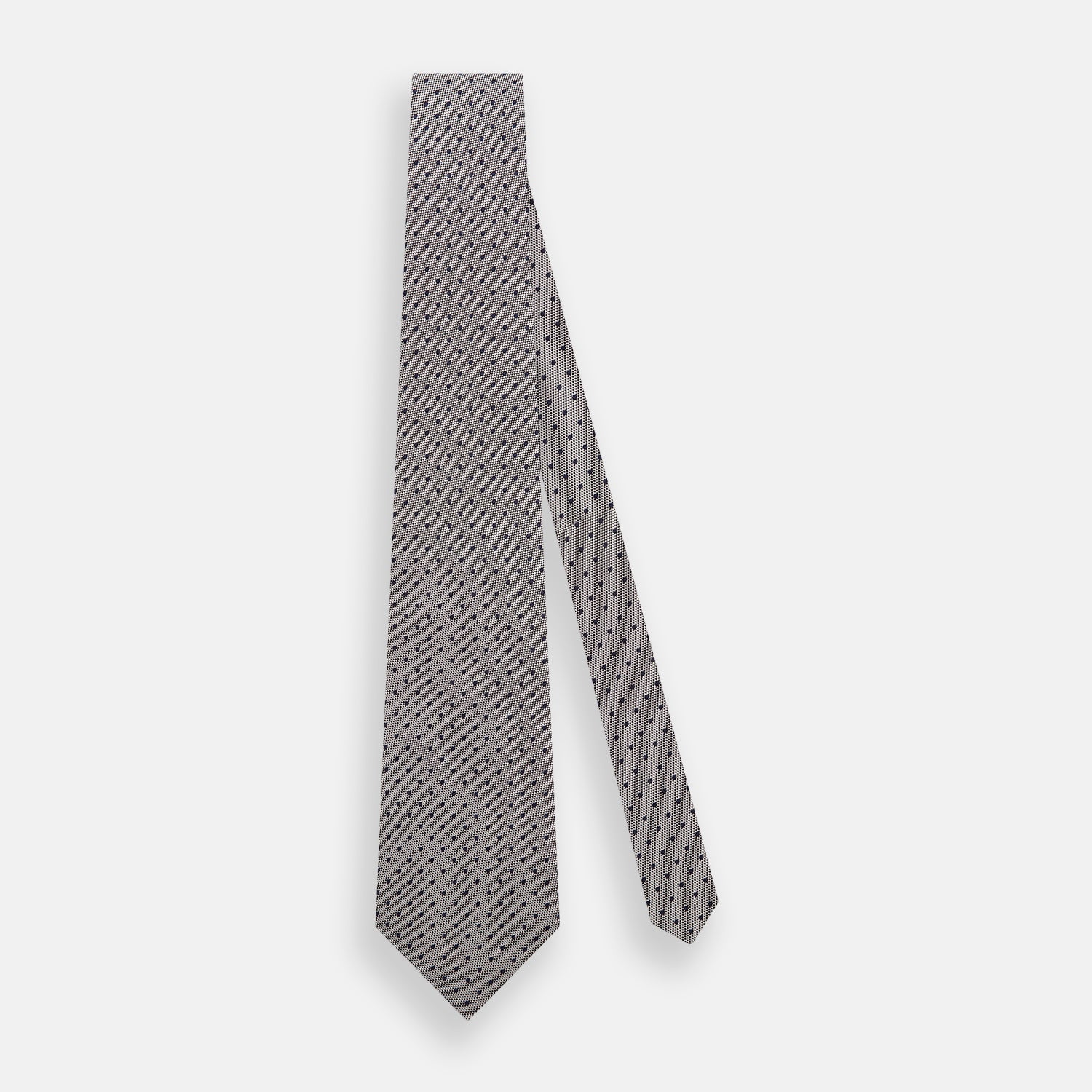 View 2 of product The Turnbull & Asser Navy and Lilac Micro Dot Silk Tie is shown rolled up on a white background, featuring a refined pattern of small lilac dots on navy silk.