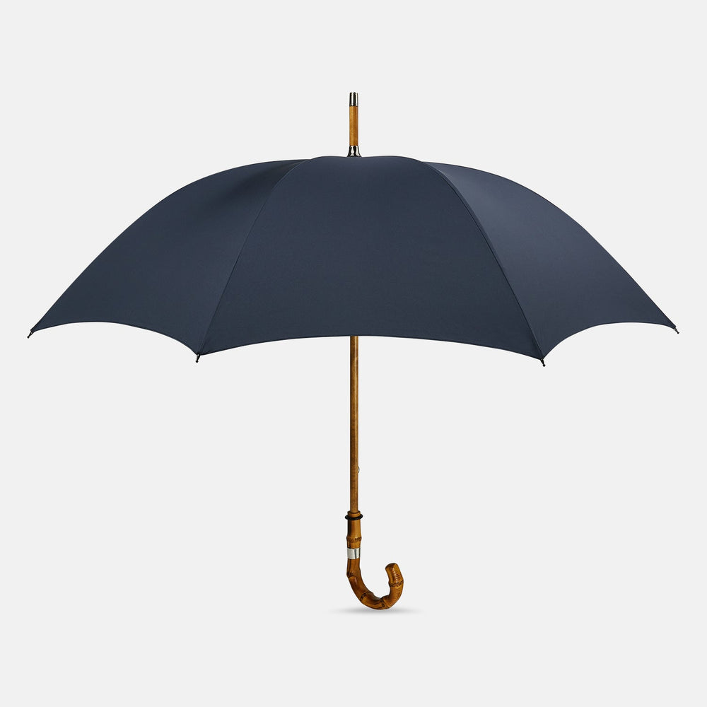 The Turnbull & Asser Navy Umbrella with Whangee Crook Handle is fully open, displaying its dark blue canopy and wooden curved handle against a plain white background.