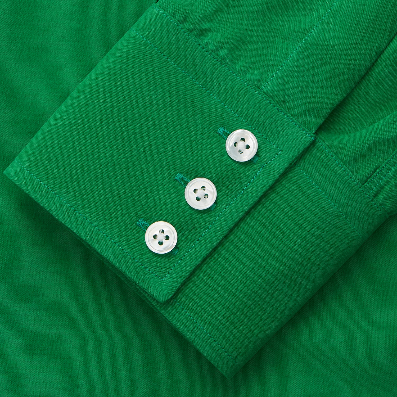 View 3 of product The Green Sandwashed Silk Regular Fit Mayfair Shirt by Turnbull & Asser, featuring long sleeves, a T&A collar, and white buttons, is displayed flat on a white background.
