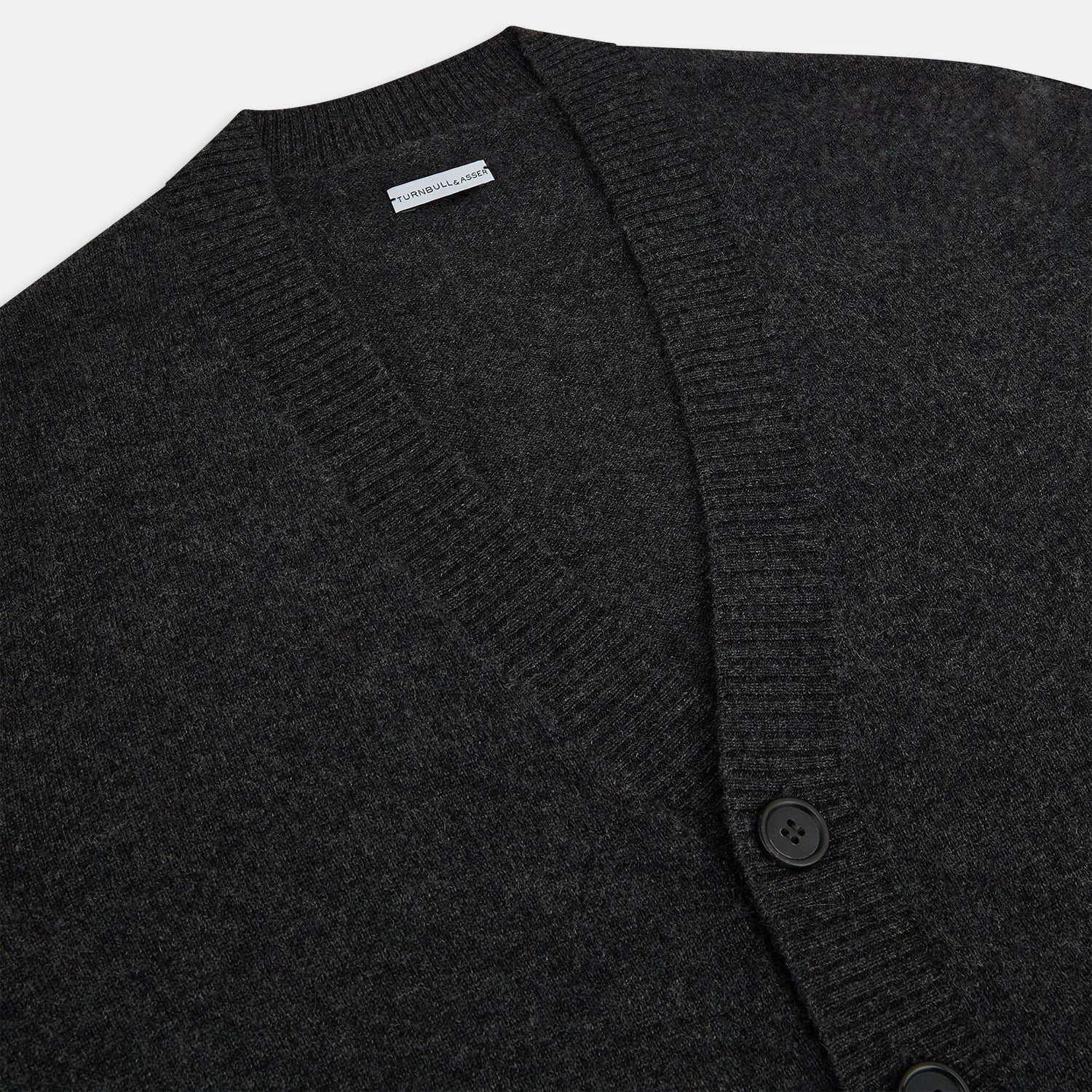 View 2 of product The Turnbull & Asser Dark Grey Melange Cashmere Cardigan features long sleeves, ribbed cuffs and hem, and two front pockets, shown on a plain white background.