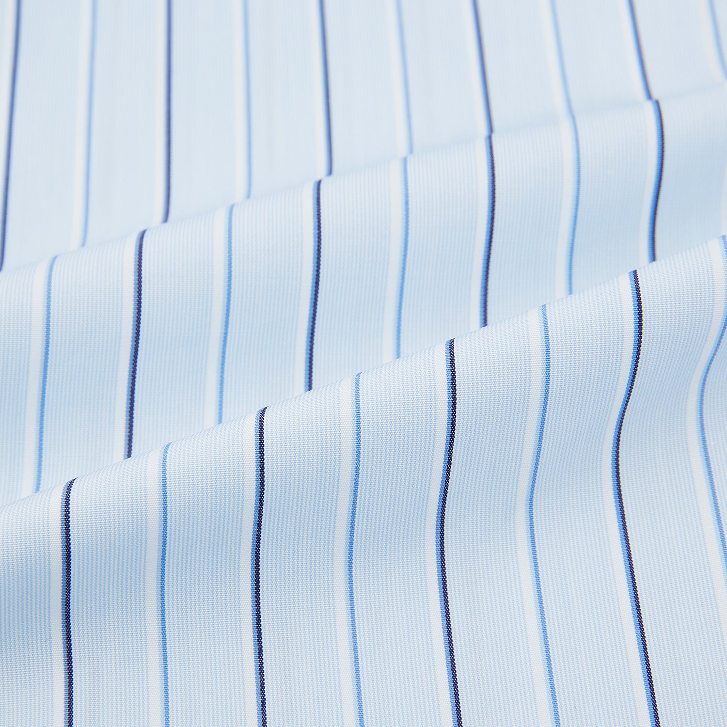 View 6 of product The Turnbull & Asser Navy and Blue Combination Stripe Mayfair Shirt, featuring thin vertical stripes and a classic collar, is displayed laid flat on a white background.