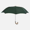 View 1 of product The Turnbull & Asser Forest Green Telescopic Umbrella with a whangee crook handle is opened and displayed on a plain white background, highlighting its expert craftsmanship and timeless style.