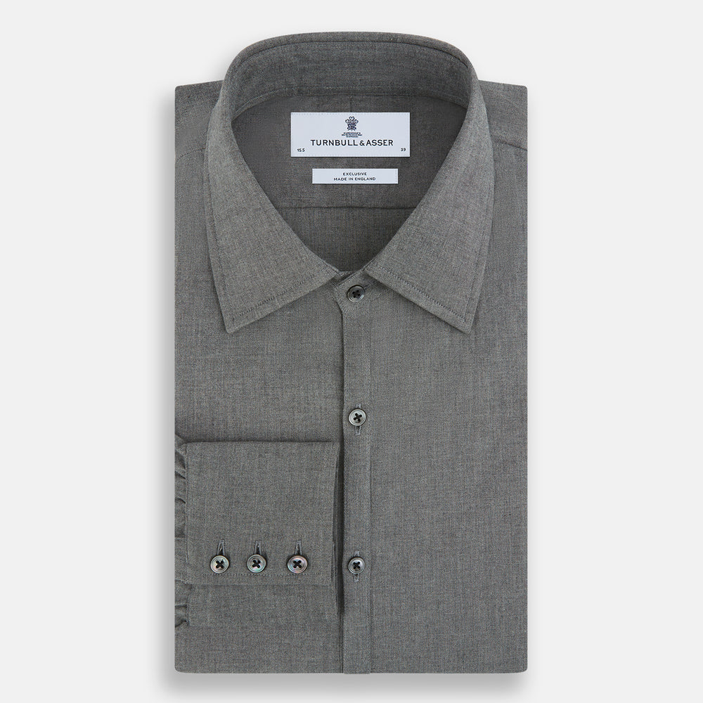 The Pale Charcoal Westminster Shirt by Turnbull & Asser features British craftsmanship with a tailored silhouette, long sleeves, pointed collar, buttoned cuffs, and a solid pale charcoal hue, elegantly shown against a white background.