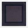 View 4 of product The Turnbull & Asser Navy and Pink Dot Silk Pocket Square features small pink dots and a solid border, with one corner folded to display both sides—an elegant accessory that reflects fine handmade craftsmanship.