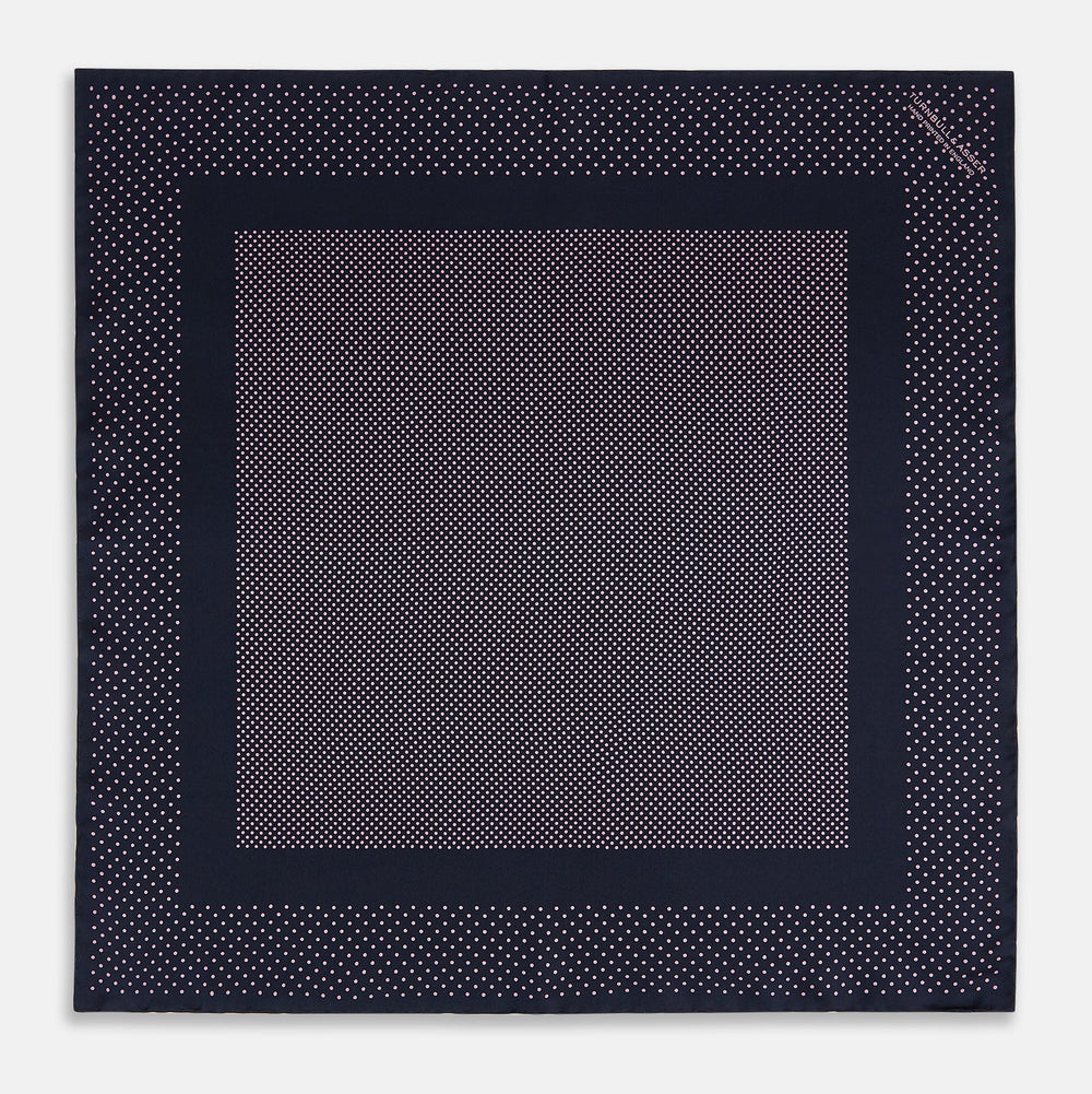 The Turnbull & Asser Navy and Pink Dot Silk Pocket Square features small pink dots and a solid border, with one corner folded to display both sides—an elegant accessory that reflects fine handmade craftsmanship.