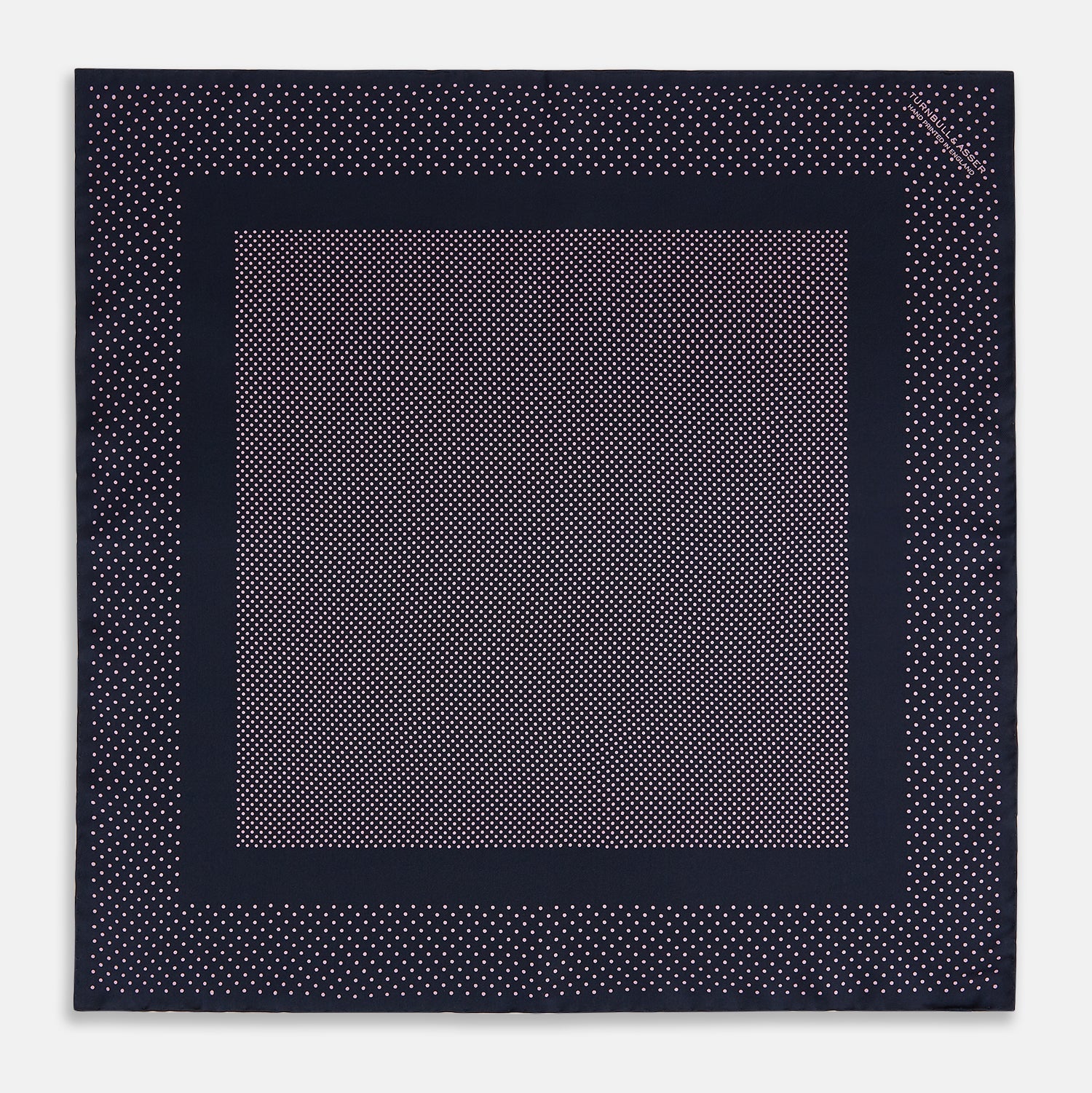 View 4 of product The Turnbull & Asser Navy and Pink Dot Silk Pocket Square features small pink dots and a solid border, with one corner folded to display both sides—an elegant accessory that reflects fine handmade craftsmanship.