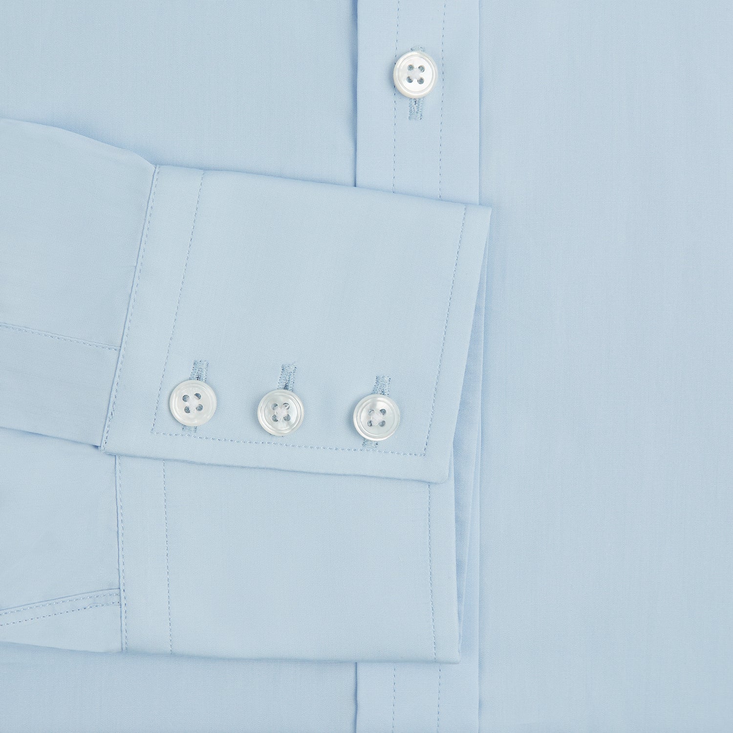 View 4 of product The Turnbull & Asser Light Blue Sea Island Quality Cotton Shirt features a T&A collar, 3-button cuffs, and premium cotton fabric, shown laid flat against a white background.