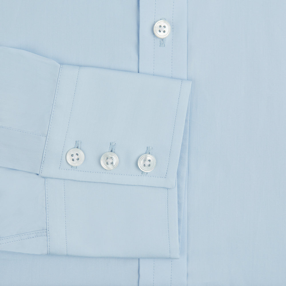 The Turnbull & Asser Light Blue Sea Island Quality Cotton Shirt features a T&A collar, long sleeves, and 3-button cuffs, beautifully displayed flat on a white background.