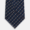 View 3 of product The Blue and White Geometric Silk Tie by Turnbull & Asser, featuring a pattern of small squares and dots, is shown rolled up against a plain white background.