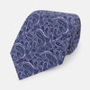 View 1 of product The Turnbull & Asser Lilac Paisley Silk Tie, crafted in England, features a blue paisley pattern on a lilac background and is shown rolled up against a white surface.