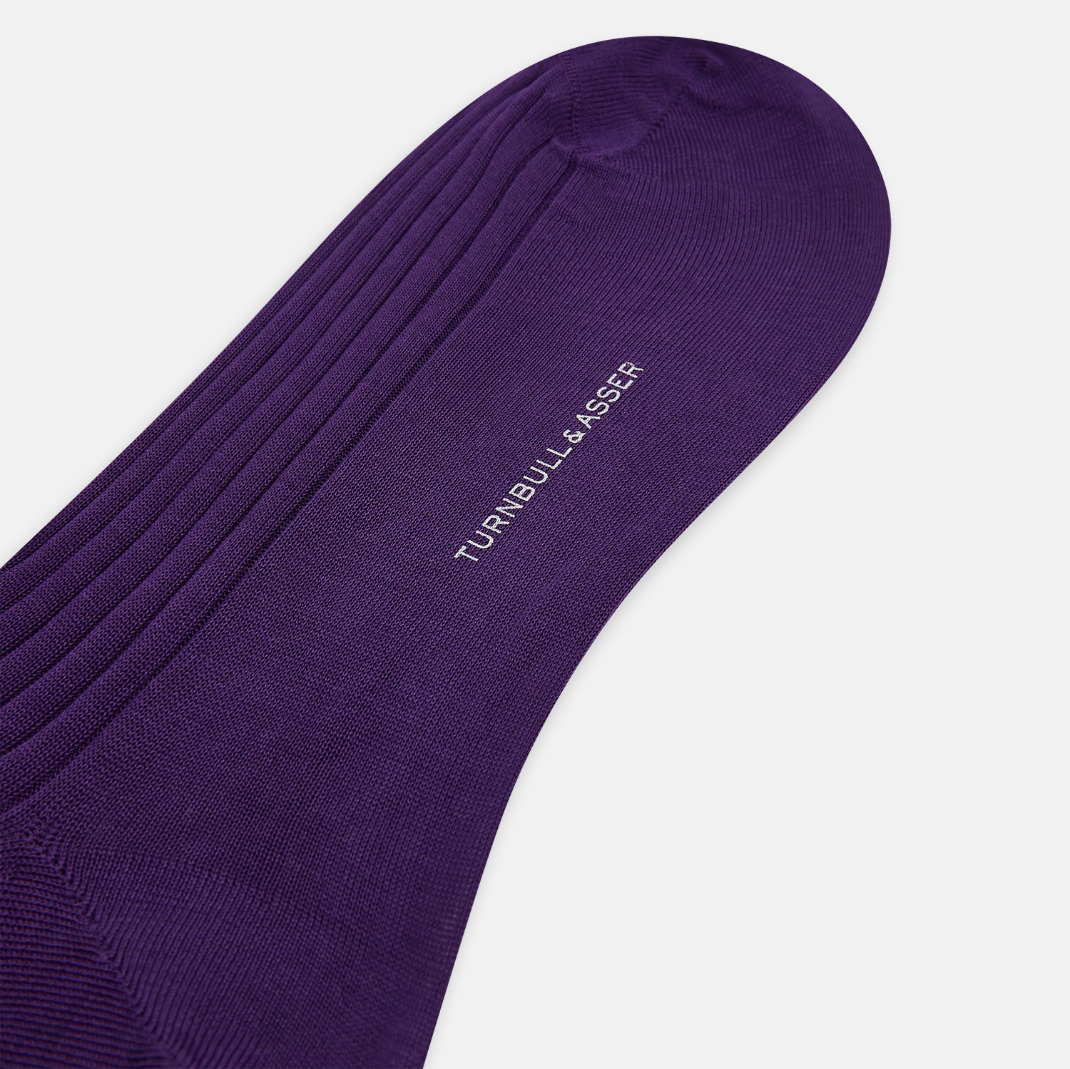 View 3 of product A single knee-high Purple Long Sock from Turnbull & Asser, made of ribbed mercerised Egyptian cotton, is displayed upright on a plain light gray background.