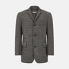 View 1 of product The Fulham Shadow Grey Single-Breasted Quilted Blazer by Turnbull & Asser features a checkered pattern, notched lapel, three front buttons, chest pocket, and two flap pockets—ideal for formal wear on a plain white background.
