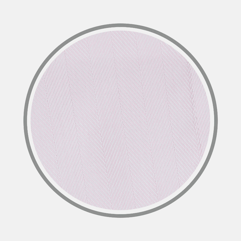 Close-up of Turnbull & Asser's Pink Herringbone Cotton Fabric, featuring a subtle herringbone pattern, displayed in a circular frame on a light gray background.