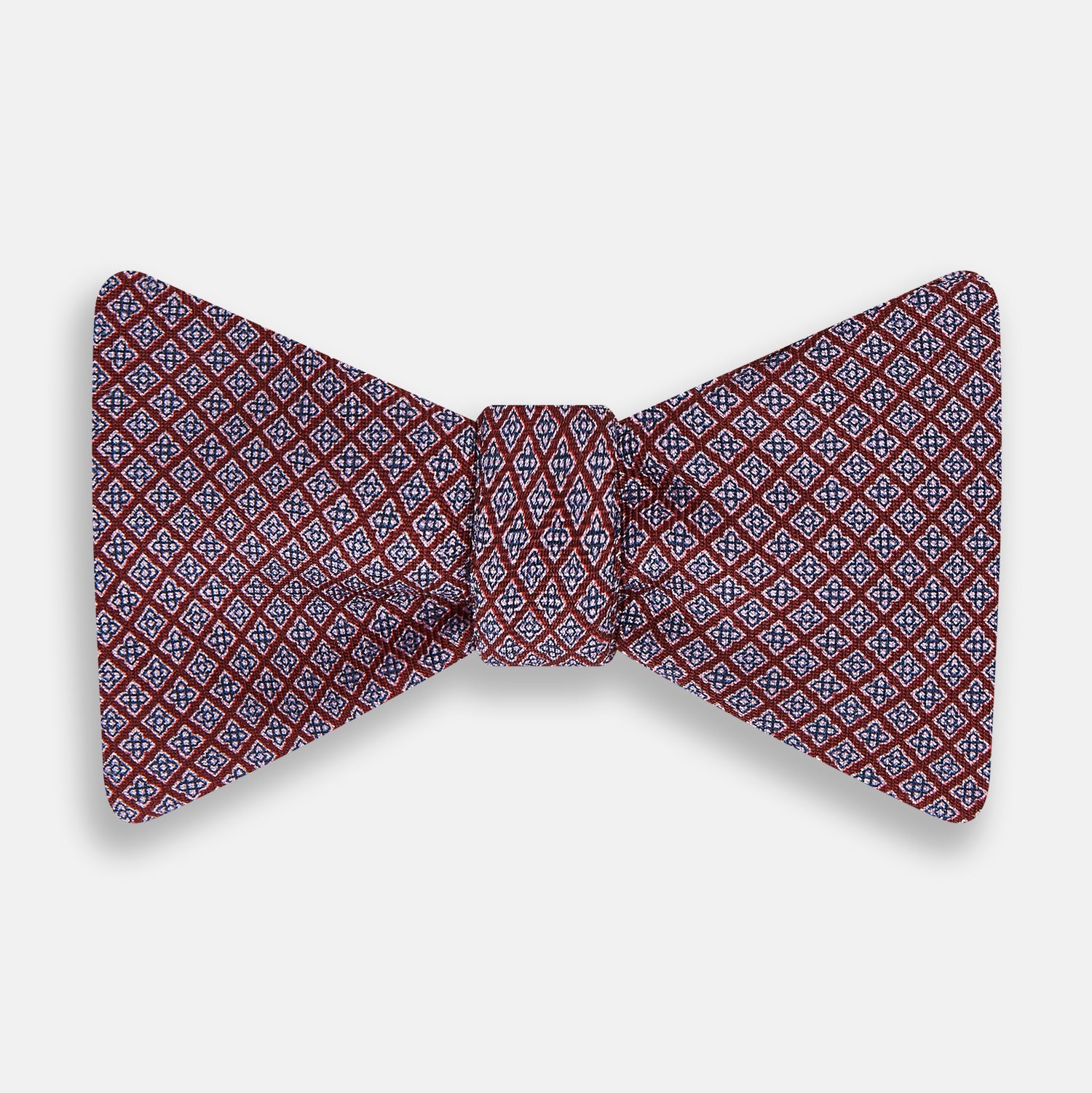 View 1 of product The Indies Red Floral Square-Print Silk Bow Tie by Turnbull & Asser features a geometric blue and white diamond pattern on red silk, styled against a white background for classic British elegance.
