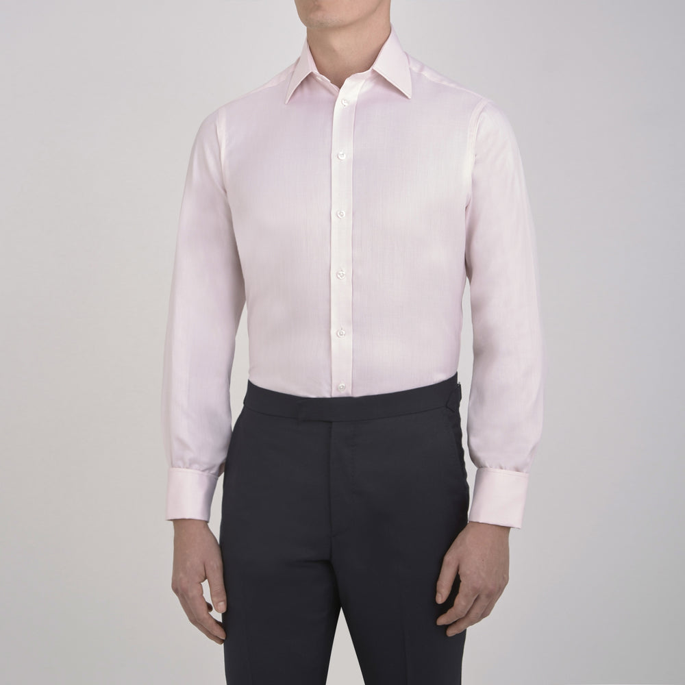 The Turnbull & Asser Pink Herringbone Superfine Cotton Shirt features a T&A collar, double cuffs, and clean-cut design, displayed neatly folded against a white background.