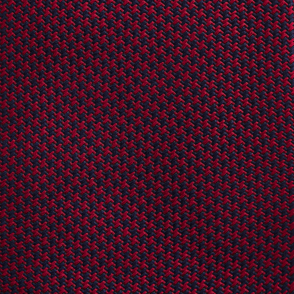 The HOUNDSTOOTH NAVY BURGUNDY TIE by Turnbull & Asser features a textured navy and burgundy silk woven pattern—an elegant staple for every gentleman’s wardrobe.
