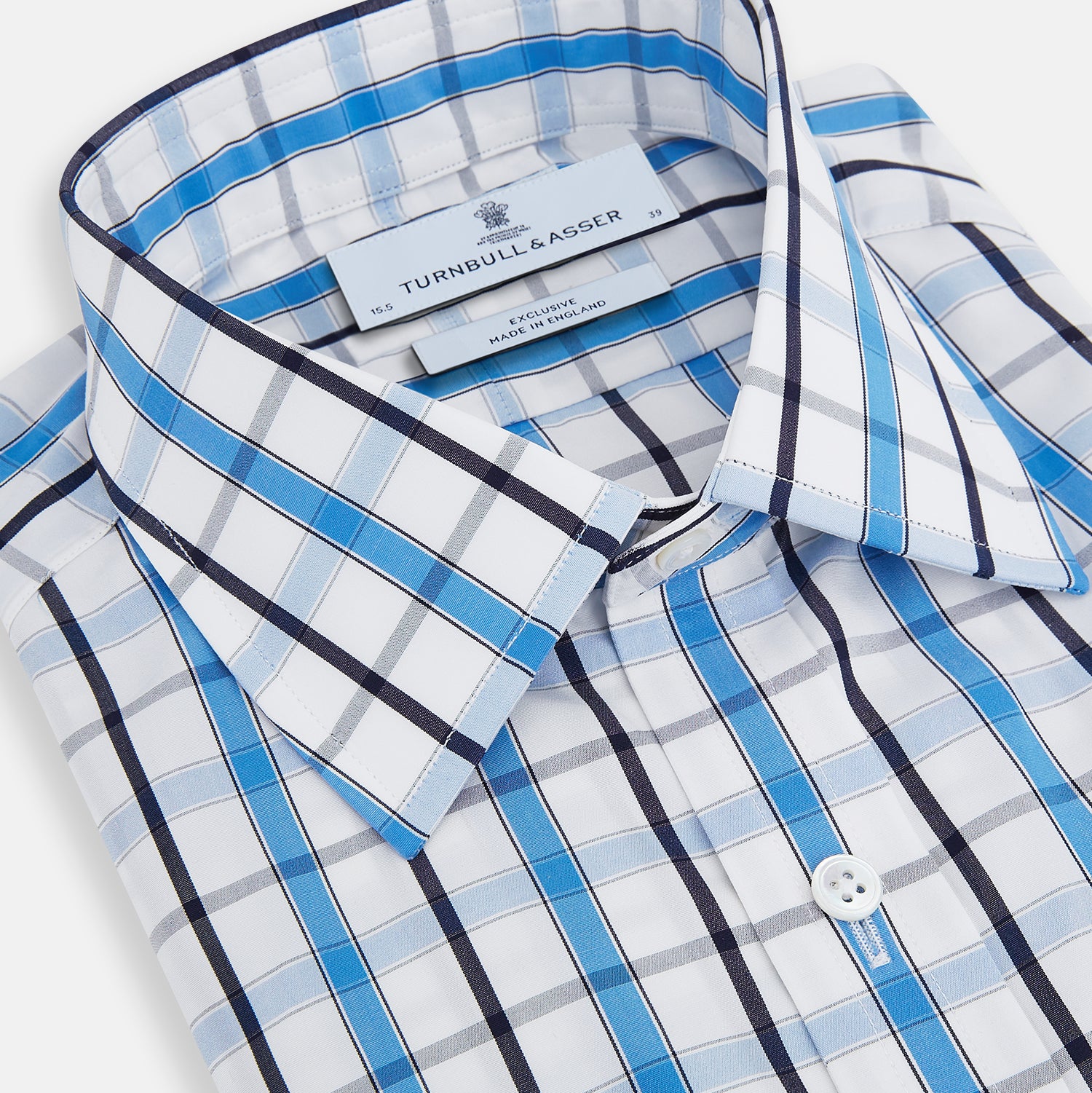 View 2 of product The Turnbull & Asser Blue and Navy Combination Check Mayfair Shirt features a classic button-up style with long sleeves, T&A collar, and a blue, navy, and white check pattern, shown against a plain white background.