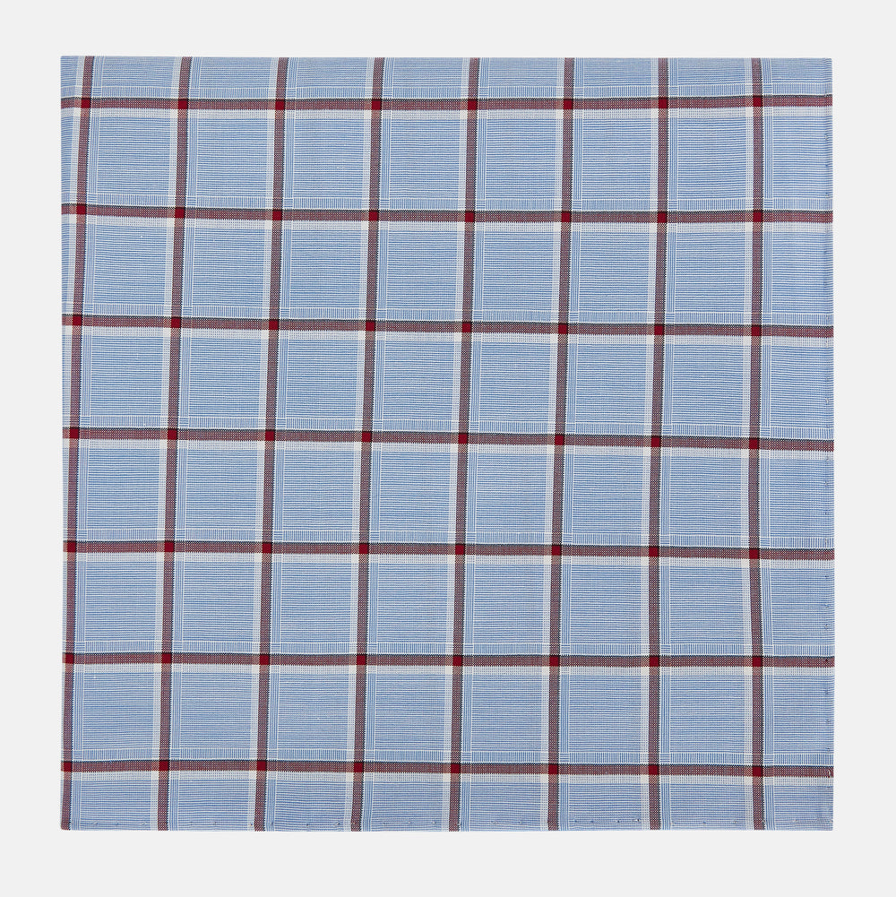 The Turnbull & Asser Blue and Burgundy Windowpane Check Hand-Rolled Handkerchief features a light blue fabric with white, red, and dark blue stripes forming a classic plaid grid.