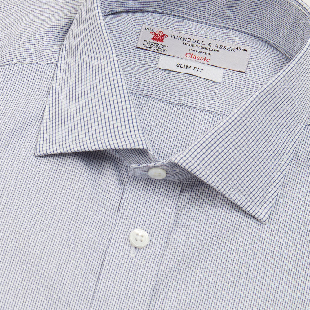 The Turnbull & Asser Slim Fit Blue Checked Shirt features long sleeves, contrasting white buttons, a regent collar, and distinct blue check pattern detailing on the cuff.