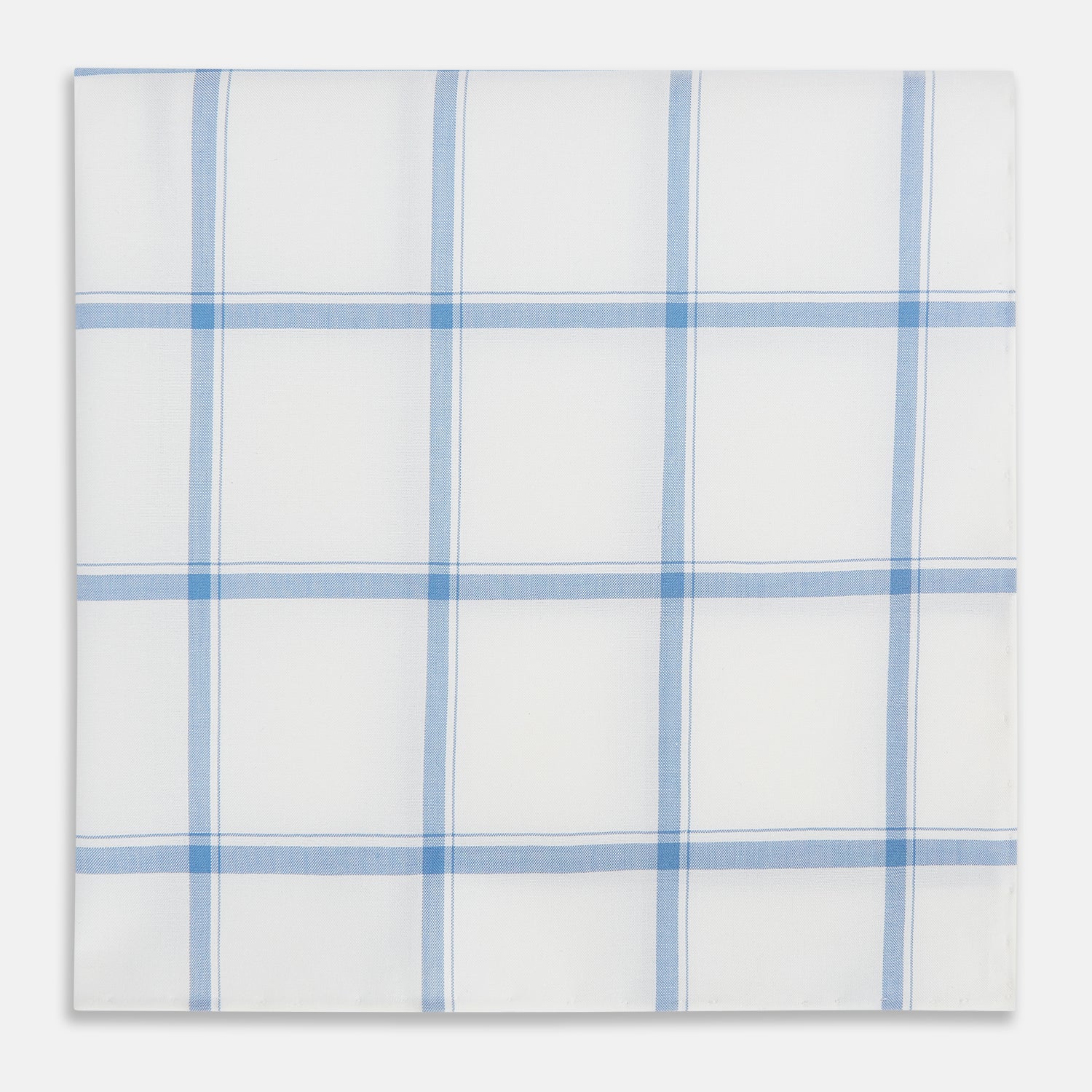 View 1 of product The Turnbull & Asser Colony Blue Grid Check Hand-Rolled Handkerchief features a white base with intersecting light and dark blue plaid lines forming squares, shown folded on a plain white background.
