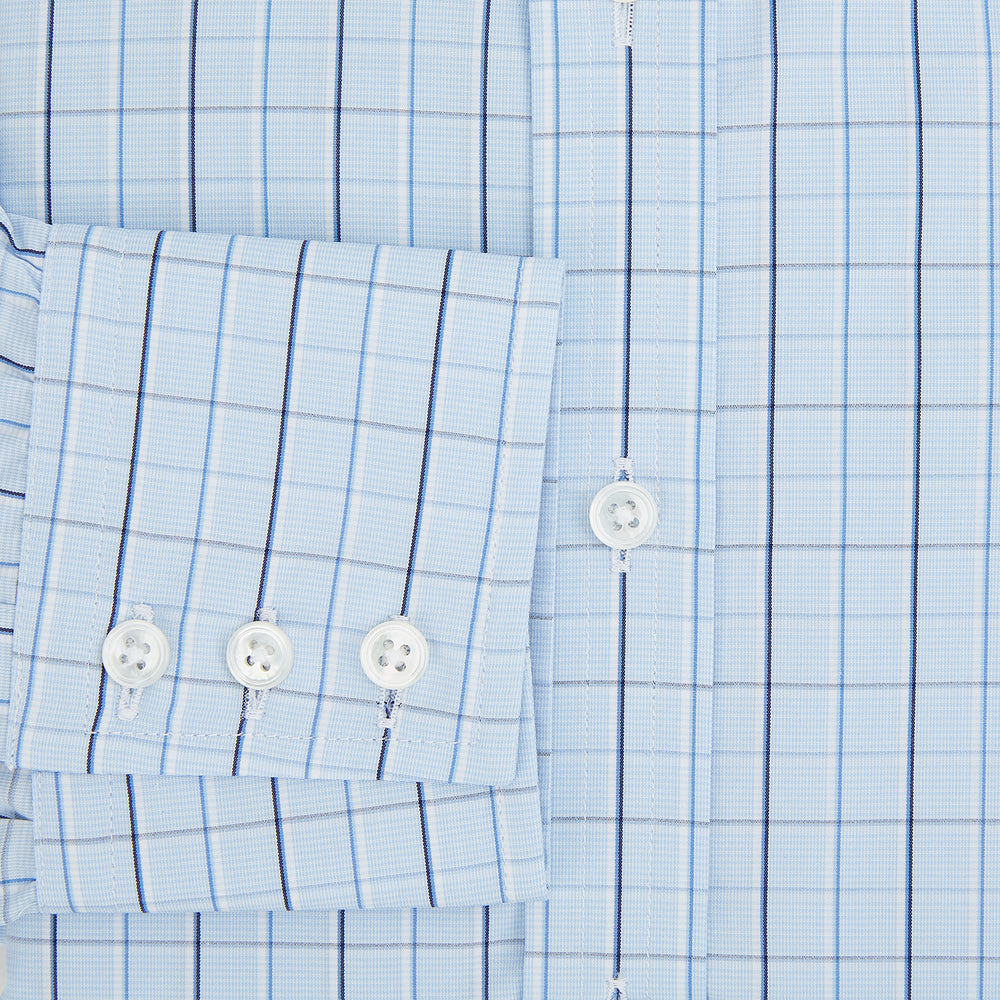 The Navy and Blue Combination Check Mayfair Shirt by Turnbull & Asser features a light blue base with a grid of thin dark blue lines, long sleeves, a pointed collar, and is neatly displayed on a plain white background.