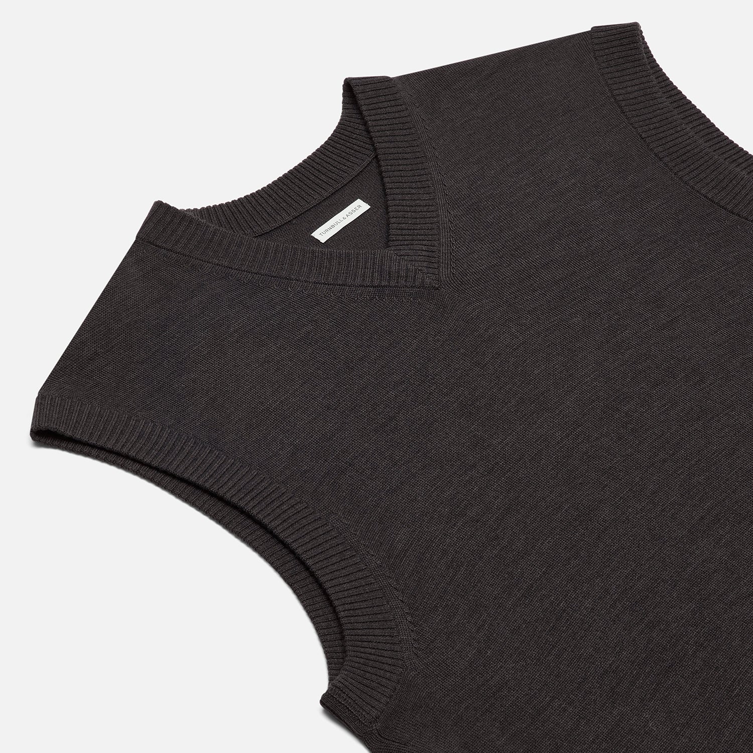 View 2 of product The Turnbull & Asser Brown Fine Merino V-Neck Vest features a sleeveless design with wide shoulders, ideal for layering in cooler seasons, shown here against a plain white background.