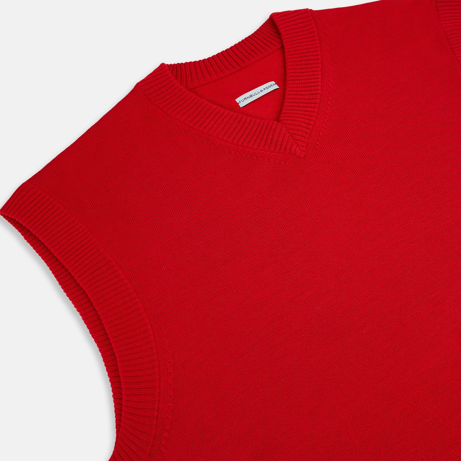 View 2 of product The Turnbull & Asser Red Fine Merino V-Neck Vest is a men's sleeveless jumper featuring ribbed edges, showcased against a plain white background.