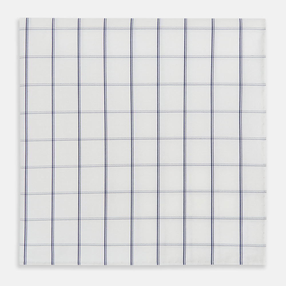 The Turnbull & Asser Dark Navy Double-Line Check Hand-Rolled Handkerchief features a white base with intersecting navy lines and hand-rolled edges, expertly crafted in England.