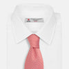 View 2 of product The Turnbull & Asser Red and White patterned silk tie, crafted from fine silk with a small geometric design, is elegantly rolled and displayed on a white background—a refined men’s accessory.