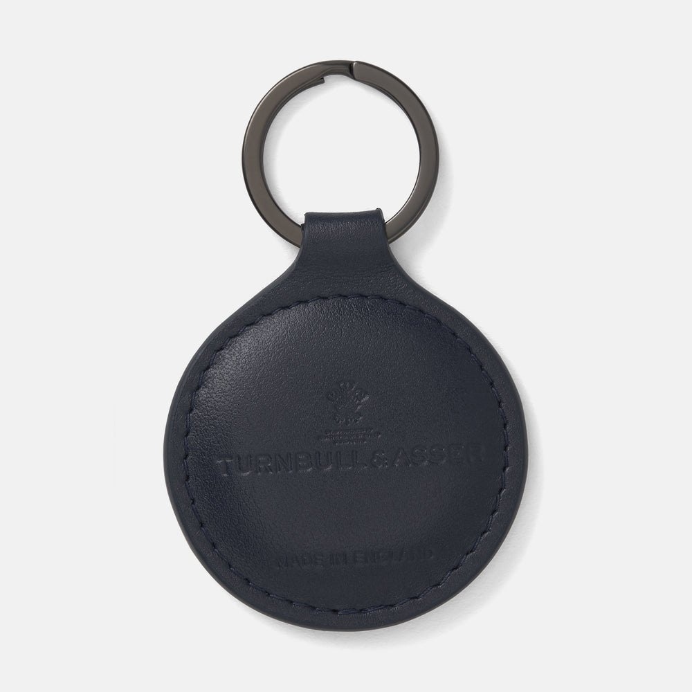 The Dark Navy Leather Fob Holder by Turnbull & Asser features round, dark blue leather with subtle embossed branding and a metallic key ring.