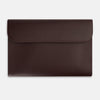 View 1 of product The Turnbull & Asser Burgundy Leather Snap-Fasten Pouch is a sleek, envelope-style laptop accessory with a smooth finish, curved flap, and elegant snap closure, ideal for business travel against a white background.