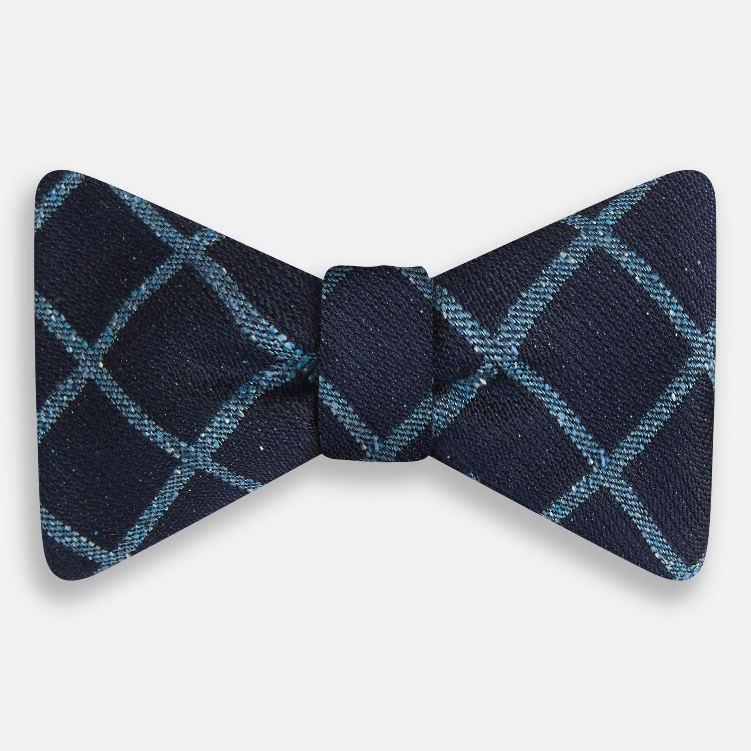 View 1 of product The Turnbull & Asser Blue Diagonal Check Silk Blend Bow Tie, shown on a plain white background, exemplifies British elegance and refined formal etiquette.