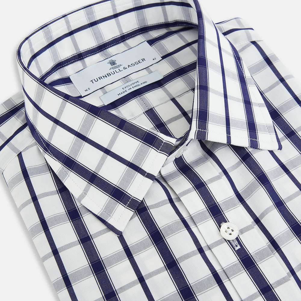 The Turnbull & Asser Navy Plaid Check Mayfair Shirt is crafted from pure cotton in white and navy checks, featuring a pointed collar and buttoned cuffs—perfect for formal looks.