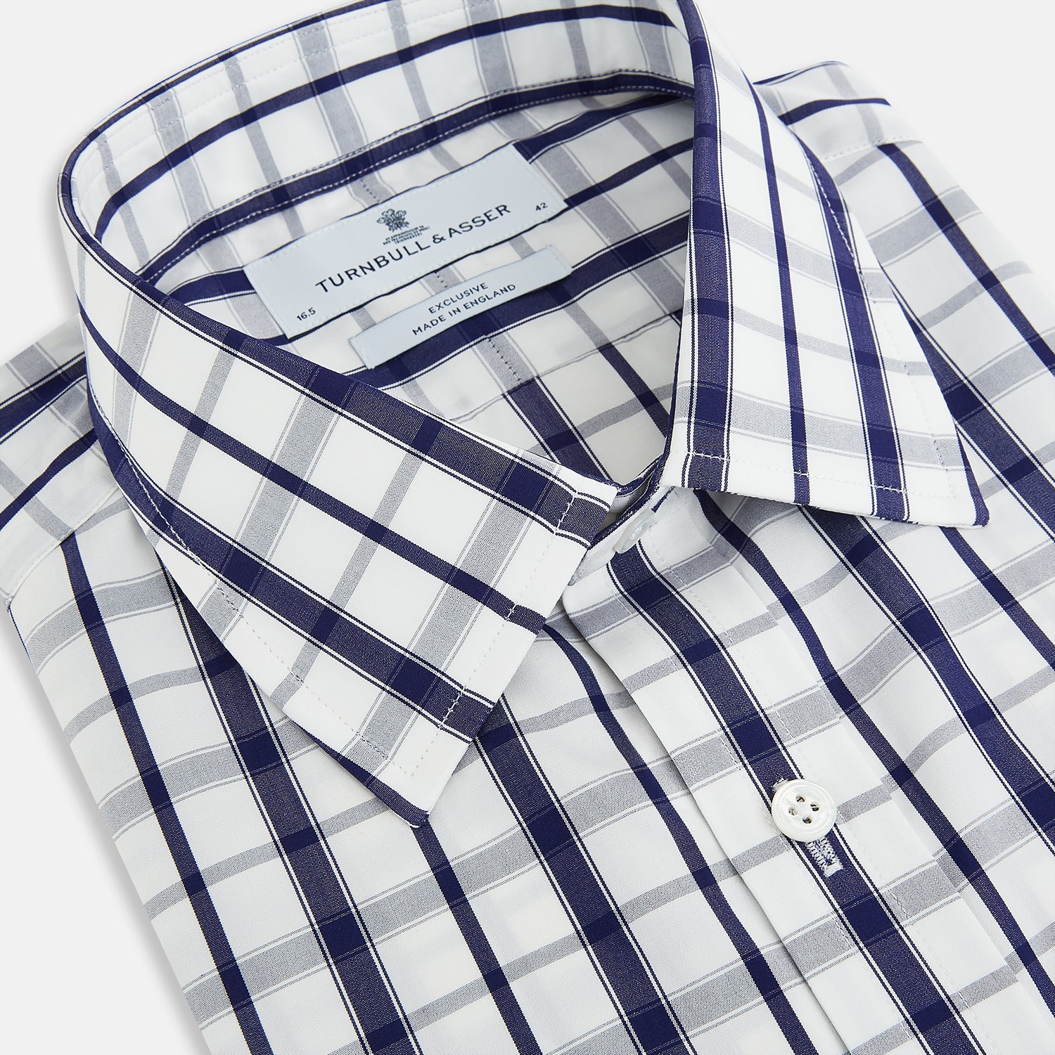 View 2 of product The Turnbull & Asser Navy Plaid Check Mayfair Shirt is crafted from pure cotton in white and navy checks, featuring a pointed collar and buttoned cuffs—perfect for formal looks.
