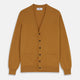 The Turnbull & Asser Golden Brown Cashmere Lachlan Cardigan features long sleeves, front buttons, two front pockets, and ribbed cuffs and hem—a luxurious knitwear piece shown laid flat on a white background.