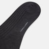 View 3 of product A single Turnbull & Asser Charcoal Long Sock, crafted from mercerised Egyptian cotton with a ribbed texture, is shown on a plain white background, positioned as if worn with the heel slightly raised.