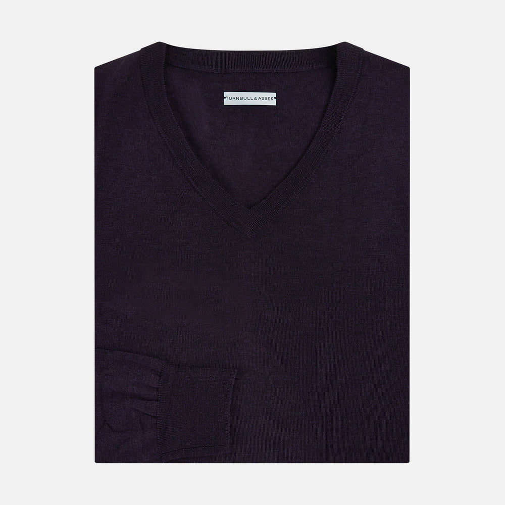 The Turnbull & Asser Dark Purple Fine Merino V-Neck Jumper features long sleeves and a classic knit, shown against a white background.
