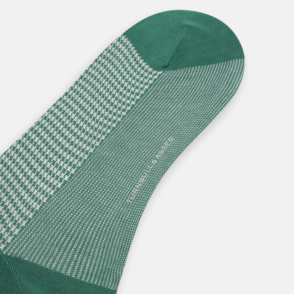 The Turnbull & Asser Ivory Houndstooth Mid-Length Sock features a green and white houndstooth pattern with solid green cuff, heel, and toe accents. Displayed on a plain white background.