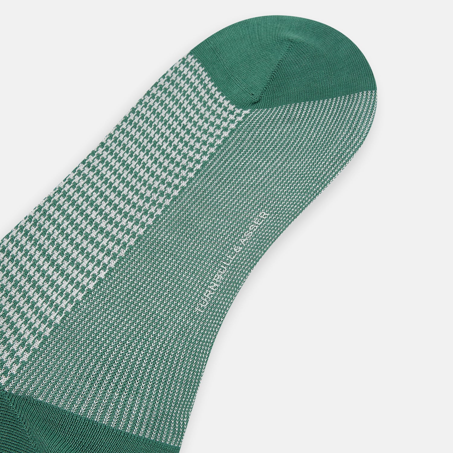 View 3 of product The Turnbull & Asser Ivory Houndstooth Mid-Length Sock features a green and white houndstooth pattern with solid green cuff, heel, and toe accents. Displayed on a plain white background.