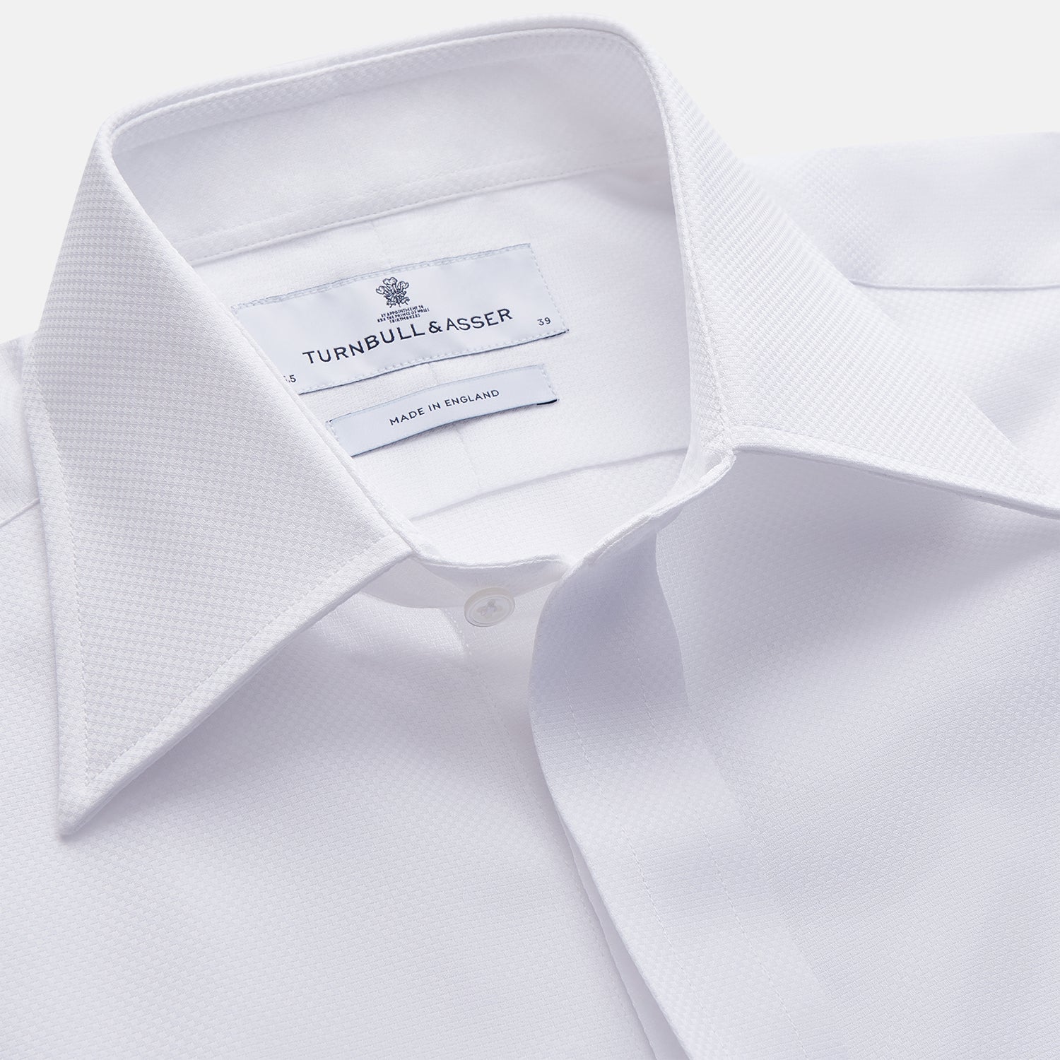 View 2 of product The Turnbull & Asser WHITE TAILORED FIT DRESS SHIRT features a pointed collar, buttoned cuffs, and a concealed button placket, shown on a plain white background.
