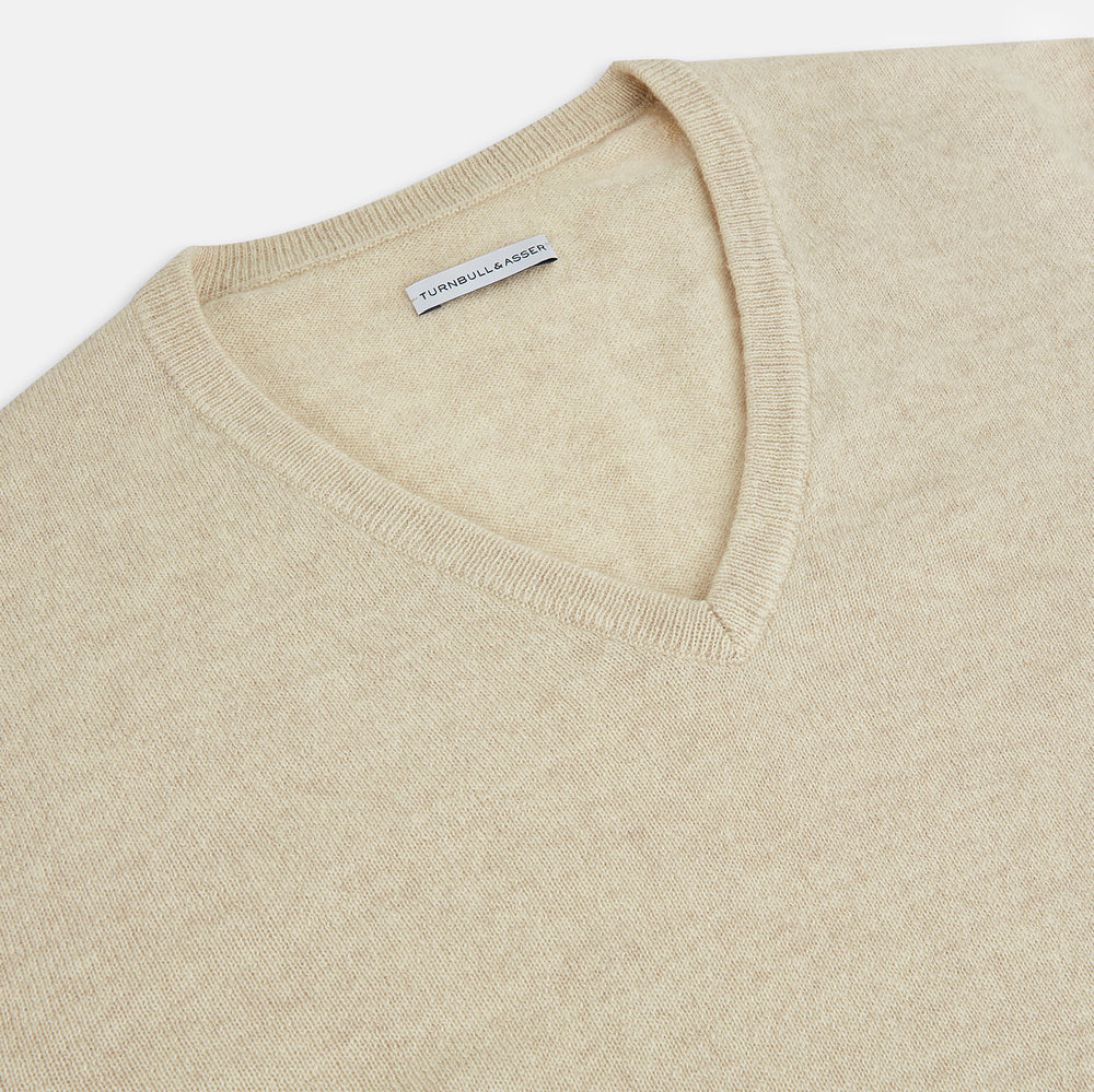 The Turnbull & Asser Ivory Cashmere V-Neck Jumper, with long sleeves and ribbed cuffs and hem, is shown against a plain white background.