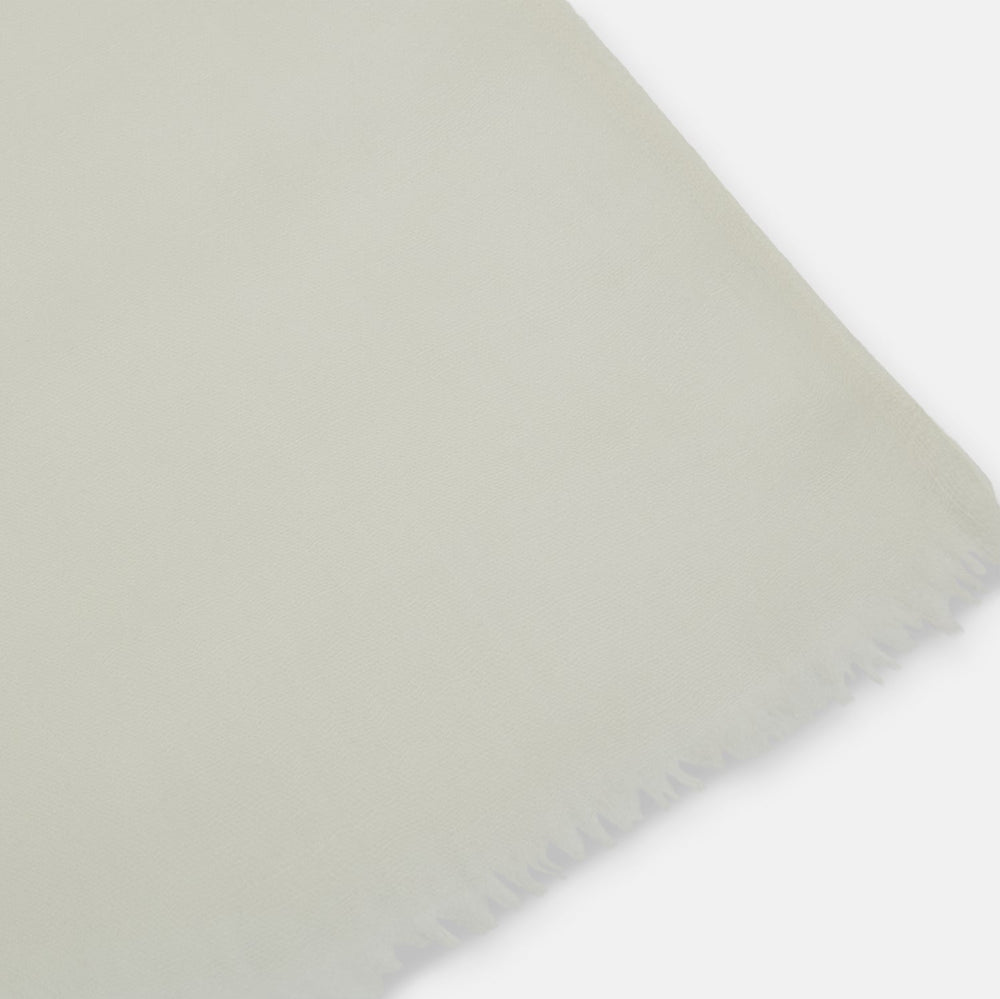 The Turnbull & Asser White Hand-Dyed Cashmere Scarf is sheer, lightweight, and shown hanging with a loose knot against a plain white background.