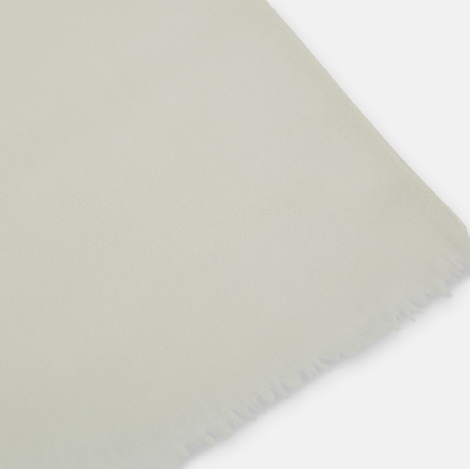 View 2 of product The Turnbull & Asser White Hand-Dyed Cashmere Scarf is sheer, lightweight, and shown hanging with a loose knot against a plain white background.