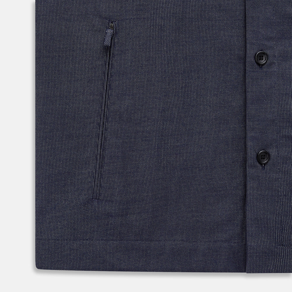 The Turnbull & Asser Navy Hampstead Overshirt features a collar, left chest pocket, two zippered pockets near the bottom, and a classic long-sleeve button-up design, shown laid flat on a white background.