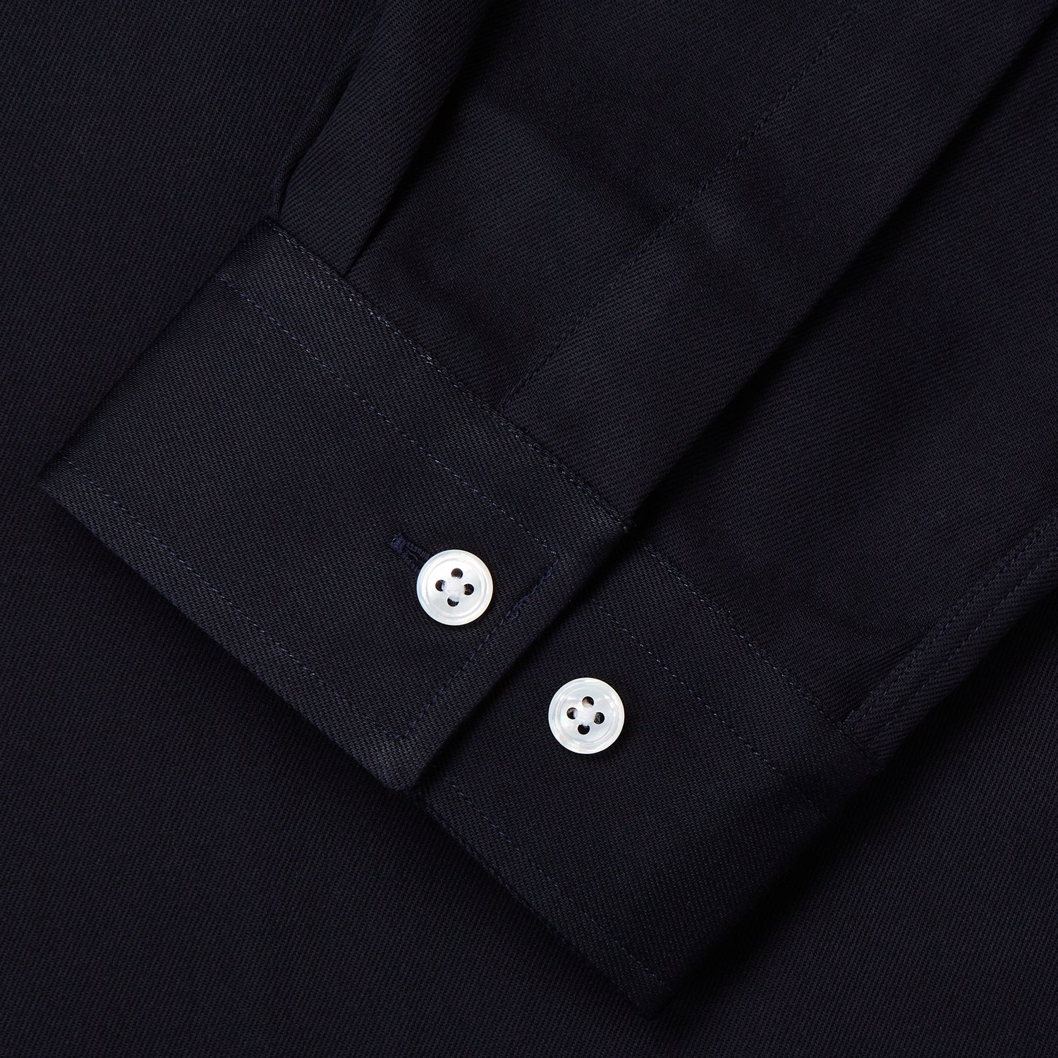 View 3 of product A Navy Cotton Holiday Fit Winnington Shirt by Turnbull & Asser, featuring long sleeves, a chest pocket, white buttons, and a revere collar, is laid flat on a white background.